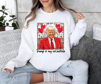 a woman sitting on a couch wearing a white shirt with a picture of a man