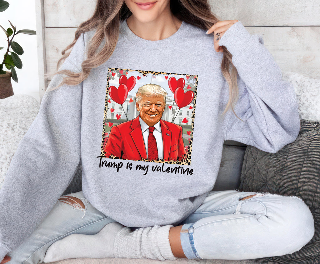 a woman sitting on a couch wearing a grey sweater with a picture of a smiling