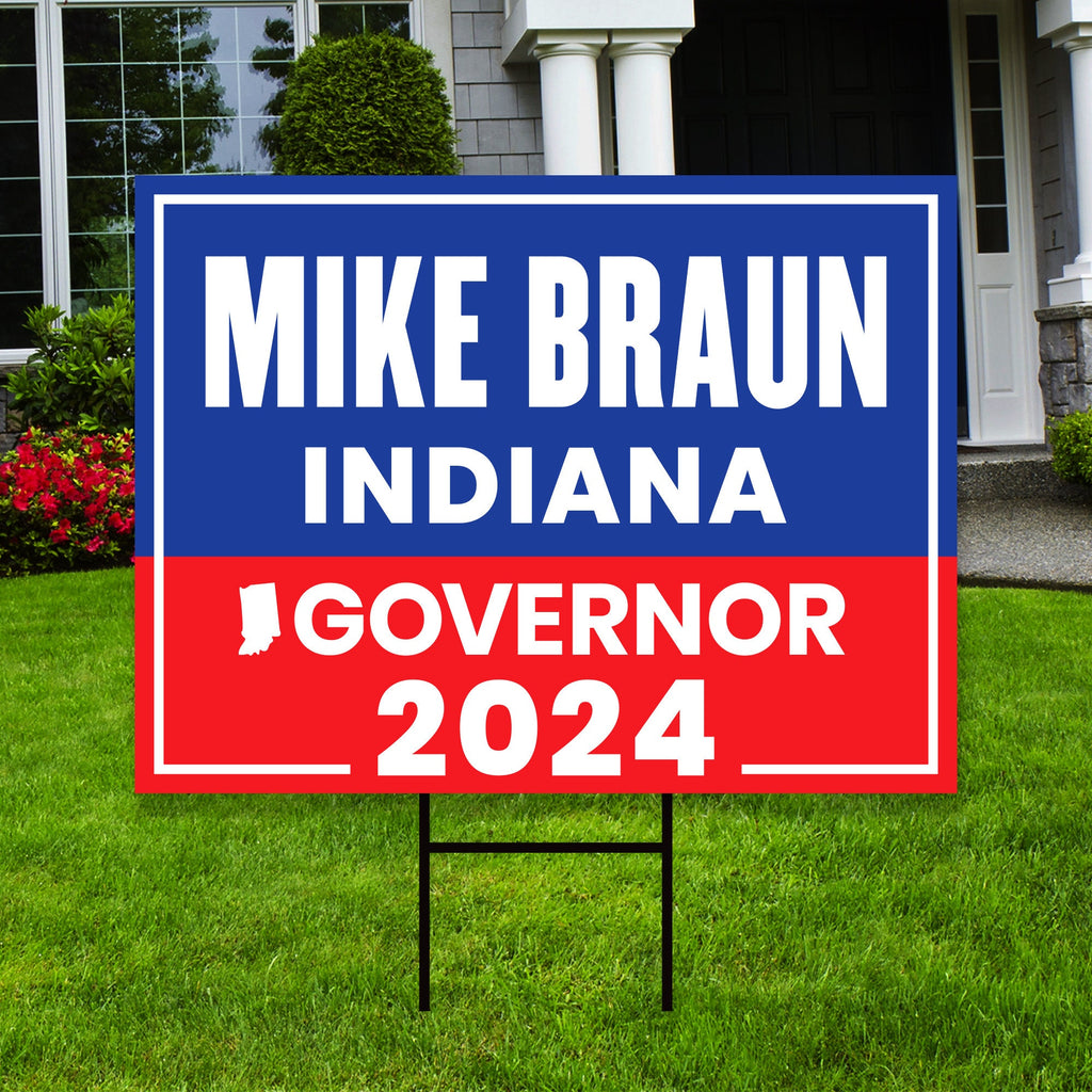 a blue and red political sign in front of a house