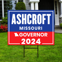 a yard sign with a house in the background